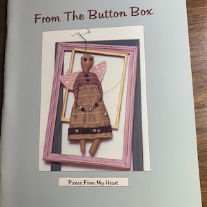 May include: A book titled "From The Button Box" with a picture of a handmade doll with wings inside a double frame. The text "Pieces From My Heart" is below the image.