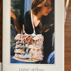Może przedstawiać: Wzór szycia na torbę o nazwie "The Trixie Bag" od "purse strings - unique patterns for unique women". Wzór zawiera zdjęcie kobiety w czarnej koszuli i dżinsach, trzymającej torbę z kwiatowego materiału z falbankami.