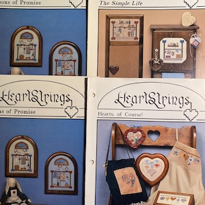 May include: Four different HeartStrings cross-stitch patterns. The patterns are titled "Sons of Promise", "The Simple Life", "Hearts, of Course!" and "As of Promise". Each pattern features a different design, including a house, a heart, and a bunny.