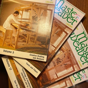 May include: A selection of vintage "Master Weaver" library books. The covers display a green title and a sepia-toned image of a person weaving on a loom. The books are titled "Volume 3" and "Volume 12", with text about weaving techniques.