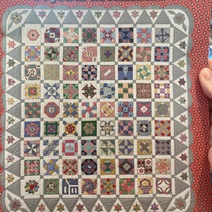 May include: Aunt Grace Scrapbag by Judie Rothermel Tenth Anniversary Edition book cover. The cover features a colorful patchwork quilt design with various patterns and colors. The background is red with white stars, and the border is gray.