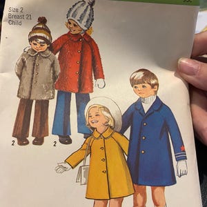 Może przedstawiać: Vintage wzór krawiecki Simplicity z ilustracjami płaszczy dla dzieci. Wzór przedstawia czerwony płaszcz, żółty płaszcz i niebieski płaszcz. Tekst na wzorze brzmi "Size 2 Breast 21 Child".