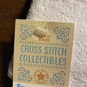 May include: A white cross stitch pattern card with a blue and brown grid. The card features the text "14 Count Border", "Cross Stitch Collectibles", "Crafted with Pride in America", "Charles Craft, Inc.", "Park Avenue/FT", "PT-6681-1H", and "White".