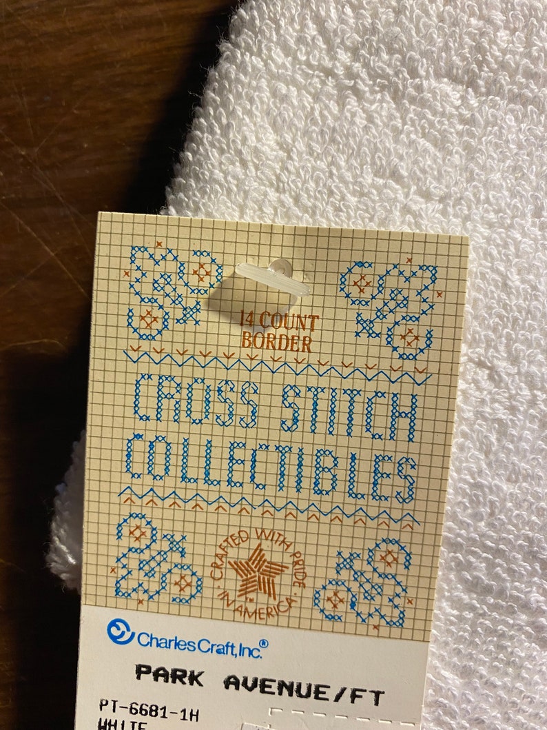 May include: A white cross stitch pattern card with a blue and brown grid. The card features the text "14 Count Border", "Cross Stitch Collectibles", "Crafted with Pride in America", "Charles Craft, Inc.", "Park Avenue/FT", "PT-6681-1H", and "White".