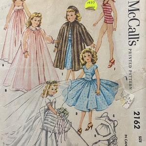 May include: A vintage sewing pattern for a doll's wardrobe. The pattern is for high heel figure dolls and includes a nightgown, a cape, a dress, a swimsuit, and a bridal gown. The pattern is from McCall's and is dated 1957.