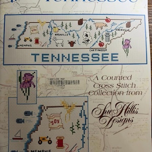 May include: A counted cross stitch pattern booklet titled Map of Tennessee by Sue Hillis Designs. The cover features a map of Tennessee with stitched icons of animals, plants, and landmarks, plus the text SHD Map 42 and a barcode.