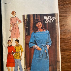 May include: A vintage sewing pattern envelope for a dress. The pattern is for size 14 and is called "Fast and Easy". The envelope shows a woman wearing a denim dress with a pocket and a belt.
