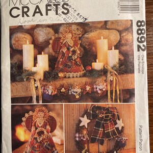 May include: A vintage McCall's Crafts pattern for a Christmas angel and wreath. The pattern is for a one-envelope project and includes instructions for making a plaid angel with a lace trim and a plaid wreath with five stars.
