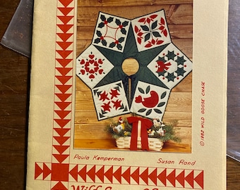 May include: A pattern for a 45-inch applique tree skirt with a red, green, and white patchwork design. The pattern is titled "Wild Goose Chase" and includes the address P.O. Box 1166, Grand Rapids, Michigan 49501.