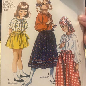 以下が含まれることがあります： 女の子用ヴィンテージSimplicityソーイングパターン。パターンは、さまざまなドレススタイルを着た3人の女の子のイラストを示しています。パターンにはサイズ12が含まれており、胸囲、ウエスト、ドレスの長さの測定値があります。Jiffyパターンは簡単に縫えます。