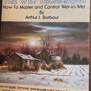 Puede incluir: Portada del libro titulada "WATERCOLOR: THE WET TECHNIQUE" de Arthur J. Barbour. La portada presenta una pintura a la acuarela de un paisaje invernal con dos edificios de madera, árboles desnudos y un campo nevado bajo una puesta de sol.
