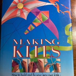 May include: A book cover titled "MAKING KITES" with colorful kite illustrations against a blue background. The cover features various kite designs in orange, white, green, and purple. Text below reads: "How to build and fly your very own kites - from simple sleds to complex stunters."