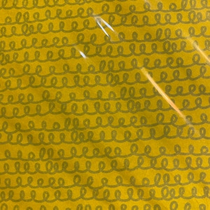 May include: A yellow fabric with a repeating pattern of dark gray loops. The fabric has a slightly textured surface.