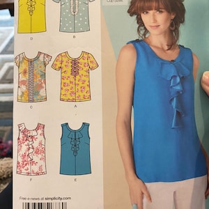 May include: A sewing pattern for a sleeveless blouse with a ruffled neckline. The pattern includes separate patterns for different cup sizes: B, C, and D. The pattern is shown on a model wearing a blue blouse with a ruffled neckline.