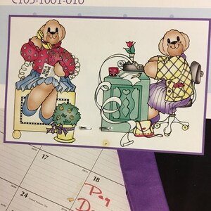 以下が含まれることがあります： 18日に「Pay Day!!」と書かれた赤い手書きのメモがあるカレンダーページ。イラストには、電話をしているテディベアと、机に座っているテディベアが描かれています。