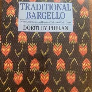 Puede incluir: Un libro titulado Traditional Bargello de Dorothy Phelan con el subtítulo Stitches, Techniques, and Dozens of Pattern and Project Ideas. La portada presenta un patrón repetitivo de formas florales naranjas y amarillas sobre un fondo oscuro.