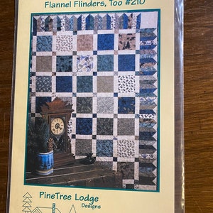 May include: A quilting pattern for a quilt called "Flannel Flinder's, Too" #210. The pattern features a blue and brown plaid design with a clock and a vase of pine branches in the foreground. The pattern is from PineTree Lodge Designs.