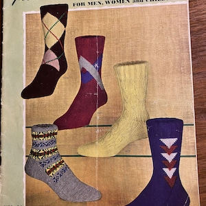 Puede incluir: Un anuncio vintage de calcetines de punto a mano Fleisher's para hombres, mujeres y niños. El anuncio presenta cinco pares de calcetines en varios colores y patrones, incluyendo un par con un patrón de diamante, un par con un patrón de estrella, un par con un patrón geométrico, un par con un patrón de chevron y un par con un patrón de triángulo. El anuncio también incluye el texto "Fleisher's Hand Knit Socks" y "Vol. 86 35¢".