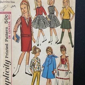 May include: Simplicity sewing pattern number 5861 for a doll-sized outfit. The pattern includes six different outfits: a red dress with a white striped shirt, a black and white checkered dress, a yellow and green dress, a floral print shirt with yellow pants, a blue coat with a white collar, and a red bodice with a white skirt.
