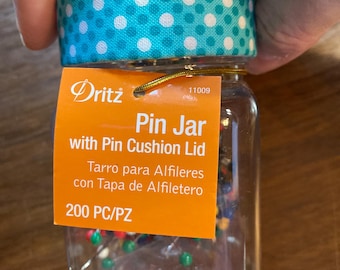 Cojín de alfileres Dritz - Almacenamiento - Accesorios de costura - Botella de plástico transparente con tapa azul de 5 cm de diámetro x 10 cm de alto - Se mantiene estable sobre la mesa - Notion