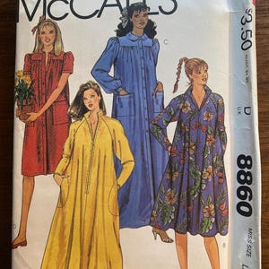 Può includere: Una busta di cartamodello vintage McCall's con illustrazioni di quattro vestaglie lunghe rosse, blu, gialle e con stampa floreale. La busta ha il numero 8860 e il testo "MISS SIZE LARGE".