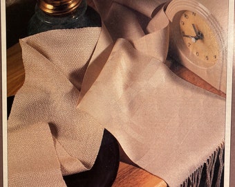 May include: A book cover featuring a beige scarf with fringe, a clock, and the text "HANDWOVEN'S DESIGN COLLECTION 15 from Interweave Press" and "Sensational Scarves".