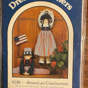 May include: A sewing pattern for two 28-inch American flag-themed dolls. The pattern is titled "#140 - American Celebration" and is from Great American Quilt Factory, Inc., 1987.
