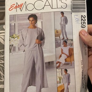 Puede incluir: Un sobre de patrón de costura McCall's para un guardarropa non-stop, modelo 2259, con ilustraciones de un abrigo largo claro, pantalones a juego, una blusa y una falda. El sobre de papel blanco muestra el nombre de la marca y las imágenes.