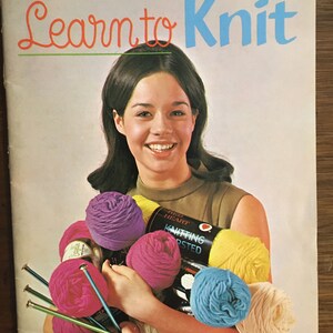 Op de afbeelding: Een vintage brei-instructieboekje met een vrouw die kleurrijke garenbollen en breinaalden vasthoudt. De omslag heeft de titel "Learn to Knit" en de prijs "35¢".