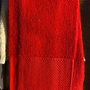 May include: A red terry cloth towel with a smaller red terry cloth square sewn onto the bottom right corner.