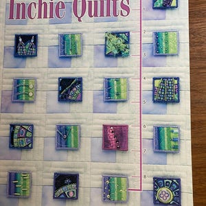 Puede incluir: La portada del libro "Inchie Quilts" muestra una cuadrícula de pequeños cuadrados de tela bordada. Estos cuadrados presentan diseños abstractos en azul, verde y morado. El nombre de la autora, Nadine Ruggles, es visible.