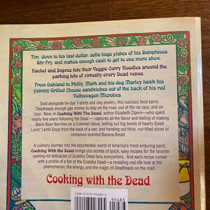 Puede incluir: La contraportada de un libro de bolsillo titulado "Cooking with the Dead" con un borde floral colorido. El libro presenta un c&oacute;digo de barras en blanco y negro y el texto "ISBN 0-312-95483-2". El libro trata sobre los Grateful Dead y presenta recetas de comida que se vend&iacute;a en sus conciertos.
