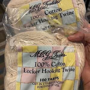 May include: Two packages of off-white 100% cotton locker hooking twine. Each label reads M.C.G. Textiles, 100% Cotton, Locker Hooking Twine, 100 Yards, Cut in 1 Yard Lengths for Ease of Use, Chino, CA 91710, www.mcgtextiles.com.