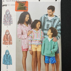 May include: Simplicity sewing pattern R11751, easy-to-sew, for sizes XS-L/XS-XL, featuring four people wearing hooded sweatshirts with different patterns and colors. The pattern includes instructions for making a hooded sweatshirt with a pocket.