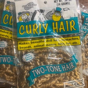 Puede incluir: Múltiples paquetes de pelo de muñeca mini-rizado de dos tonos. Los paquetes están etiquetados como "Curly Hair" y "Two-Tone Hair" con ilustraciones de dibujos animados. El peso neto es de 14 gramos.