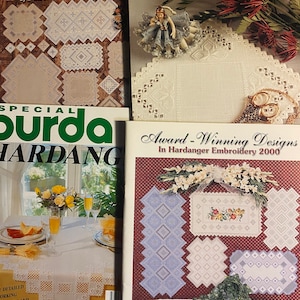 Peut inclure: Trois livres sur la broderie Hardanger, présentant une variété de motifs et de modèles. Les livres sont intitulés "Hardanger: A Growing Tradition", "FLC Traditional White" et "Special Burda Hardang".