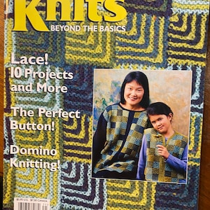 Op de afbeelding: Een tijdschriftcover voor Interweave Knits, een publicatie voor breiers. De cover toont een foto van twee mensen die gebreide kleding dragen met een geometrisch patroon. De tekst op de cover luidt "Lace! 10 Projects and More, The Perfect Button!, Domino Knitting!" en "Spring 1997".