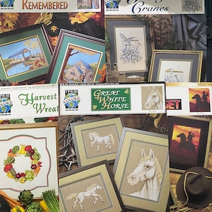 May include: A collection of cross-stitch patterns featuring various themes, including a fall scene, a harvest wreath, a graceful crane, a great white horse, and a sunset. The patterns are printed on colorful paper with the title "True Colors" and the name of the design.