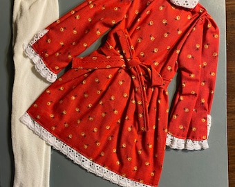 Könnte beinhalten: Ein rotes Kleid mit weißem Spitzenbesatz und einem passenden weißen Kragen. Das Kleid hat ein Blumenmuster und eine Schleife in der Taille. Das Kleid wird mit weißen Strumpfhosen kombiniert.
