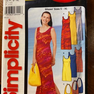 May include: Simplicity sewing pattern number 628 for Misses' sizes S-XL. The pattern includes instructions for making four different styles of sleeveless maxi dresses. The dresses are shown in a variety of colors and patterns, including red, yellow, blue, and white.