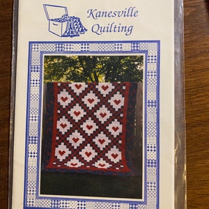 May include: A quilting pattern for a quilt called "Irish Hearts". The pattern features a red, white, and blue quilt with a heart design. The pattern is from Kanesville Quilting and is labeled KQ19.