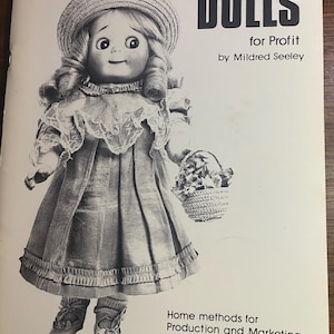 May include: A black and white photo of a book cover featuring a doll wearing a dress and a hat. The book title is "Making Reproduction Dolls for Profit" by Mildred Seeley. The book cover also includes the text "Home methods for Production and Marketing of Antique Doll Copies".