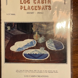 Könnte beinhalten: Ein Häkelmuster für Blockhaus-Platzsets in Herz- und Ovalform. Das Muster trägt den Titel "Log Cabin Placemats (Heart - Oval)" und enthält Anleitungen zum Herstellen der Platzsets. Das Muster stammt von Vesta M. Ropp und wurde im März 1990 veröffentlicht.
