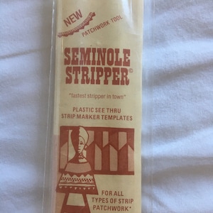 May include: A package for a Seminole Stripper patchwork tool. The package is tan with red text and graphics. The text includes "Seminole Stripper", "fastest stripper in town", and "Plastic See Thru Strip Marker Templates". The set includes 3 pieces, 1" - 1 1/2" - 2" by 16" long.