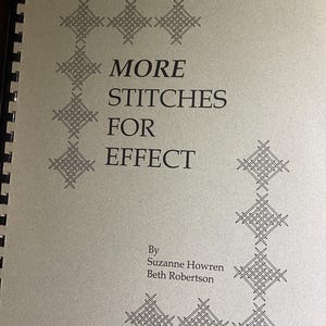 Puede incluir: Un libro con encuadernación en espiral y cubierta de color tostado claro que presenta el texto negro MORE STITCHES FOR EFFECT de Suzanne Howren y Beth Robertson. La cubierta está decorada con patrones geométricos negros en líneas verticales y horizontales.