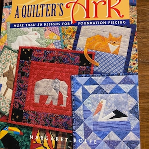 May include: A Quilter's Ark book featuring over 50 foundation piecing designs. The cover displays colorful quilt blocks with animal designs, including an elephant, cat, and stork. The author's name, Margaret Rolfe, is also visible.