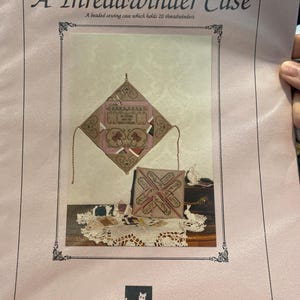 Pode incluir: Uma página rosa com o título "A Threadwinder Case" e o texto "A beaded sewing case which holds 20 threadwinders". A imagem mostra um estojo de costura com contas com um design geométrico e um estojo quadrado menor.