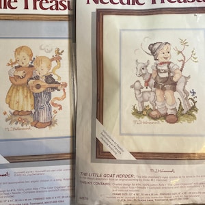 May include: Two cross-stitch kits featuring children. One shows two children with musical instruments, the other depicts a child with goats. The kits include charted designs, floss, and instructions. Frame size is 12" x 14" (30 cm x 36 cm).