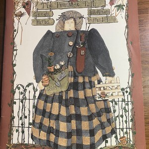 Puede incluir: Una ilustración de portada de libro vintage de una mujer con un vestido a cuadros azul y marrón que sostiene una herramienta de jardinería y una maceta de flores. El título del libro es "The Primrose Path Wildflowers by Anne McKay" con las palabras "Seeds, Herbs" en la portada.