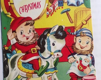 Vintage CHRISTMAS CARD for Children - Elf on Hobby Horse in Santa's Toy Workshop.  Unused with envelope Xmas Remembered - 4" x 6"